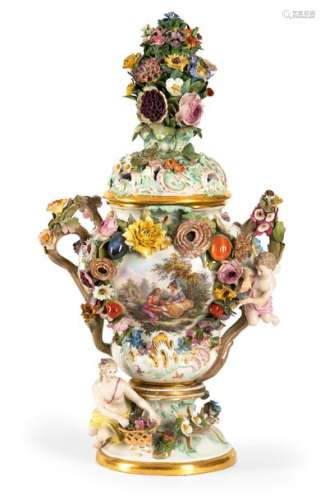 Magnificent potpourri vase. Meissen, circa 1860/70. H. 64 cm. Model made by Johann Joachim Kändler around 1760, baluster shape with flared stand, rich rocaille relief decoration. At the foot of the vase is a young woman with a flower basket as flora, below the handle is a putto. The body of the vase is decorated on both sides with luxuriant garlands of flowers, the front cartouche contains a gallant scene in the finest painting, the back shows a beautiful bouquet of flowers, with scattered flowers in between. Open-work lid with a rich, plastic flowering shrub on top. Underglaze blue sword mark on the floor. Rest., best. Provenance: Collection of the Stuttgart entrepreneur and art lover Wolfgang Osterloh. See the portrait of Wolfgang Osterloh (PDF). The vase model by Kändler was created on order of the Prussian King Frederick the Great for the New Palace in Potsdam.