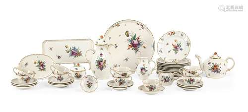 Coffee and tea service. Nymphenburg, 20th century. . Rococo shape, fine painting of bouquets and scattered flowers, rocaille decoration in gold at the edge. Consisting of 11 cups, 12 saucers, 12 cake plates, 1 cream jug, 1 milk jug, 1 sugar bowl, coffee pot, teapot, a small bowl, 1 butter dish, 1 king cake plate and a large round cake plate Pressed rhombic shield, green stamp, partly painter's numbers in purple, partly stamped 