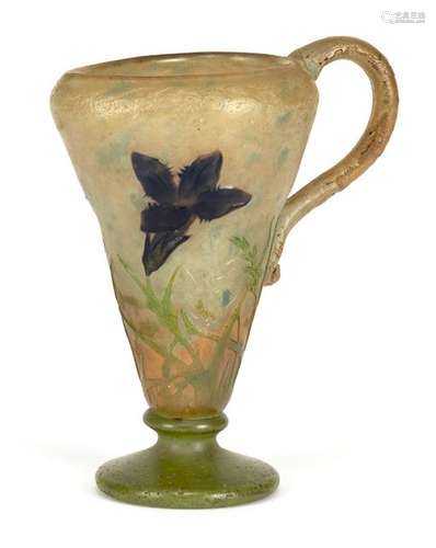 Little jug of Gentianes. Thumb, Nancy, circa 1912. H. 12 cm. Flashed glass in colourless, green, orange and blue. Etched decor of gentian, the flowers reworked with the wheel, applied handle. On wall sign. Thumb, Nancy, Lorraine Cross. Provenance: From a private collection in Stuttgart. Cf. catalogue Daum, Collection du musée des Beaux-Arts de Nancy, no. 348.