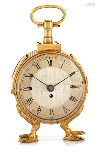 Travel clock. Vienna, circa 1830. H. 15 cm. Round glazed, richly engraved, fire-gilt bronze case on claw feet. Silver-plated, ornamentally decorated dial with windings at 