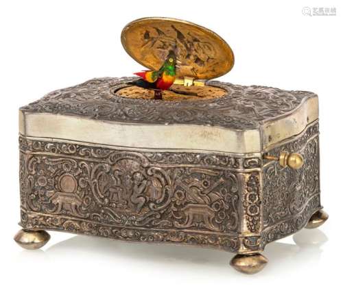 Songbird machine. German, circa 1880. 6x11x8 cm. Silver stamp 925 and devious master stamp. The box is decorated all around with music-making putti, birds and flower tendril decoration. Oval, gilded spring lid with two putti playing music. When the automaton is triggered, a colourful bird of paradise rises, turns, spreads its wings and moves its beak while whistling its song. Automatic movement with key winding, bellows and whistles. Rest. Erg. provenance: important southern German watch collection in longstanding private ownership. Acquired from Ineichen Zurich in June 1975.