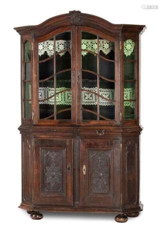 Rococo display case. West German, around 1750, formerly Benrath Castle. 205x130x46 cm. Two-piece construction. In the lower part two doors and two drawers. Top, glazed on three sides with two doors. Oak. Brass fittings. Rest. On the back there is an old dealer label: 