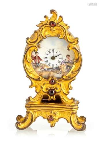 Miniature decorative clock with enamel dial. Vienna, late 19th century. H. 7 cm. Gilded brass case in rococo style. Enamel dial with figural painting, min. hairline crack. Glass block trimming. Cylinder movement.