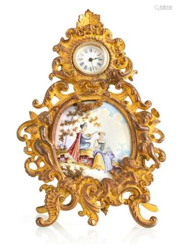 Decorative watch with enamel plaque. Vienna, late 19th century. H. Six inches. Gilded bronze and brass frame in rococo style with putto decoration. Enamel plaque with figurative painting. White enamel dial with Roman numerals and blued hands. Cylinder movement. L. Ber.