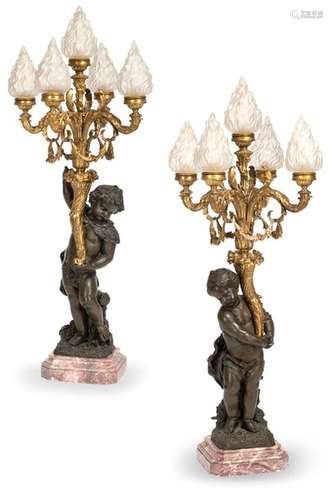 A pair of magnificent candlesticks. France, circa 1900. H. 110 cm. Five-flame. Bronze, patinated and partly gilded. Pink marble base. Flame shaped glass shades. Rest. Agessp. electrif. Large and opulent pair of candelabras with putti bearing cornucopias from which the flame-shaped candlestick arms emerge. Similar putti chandeliers were also made by Eugène Bagues, cf. Ottomeyer/Pröschel, Gold-plated bronzes, Volume 1, p. 422, Fig. 6.3.1. 2015 acquired from Drouot/Paris.