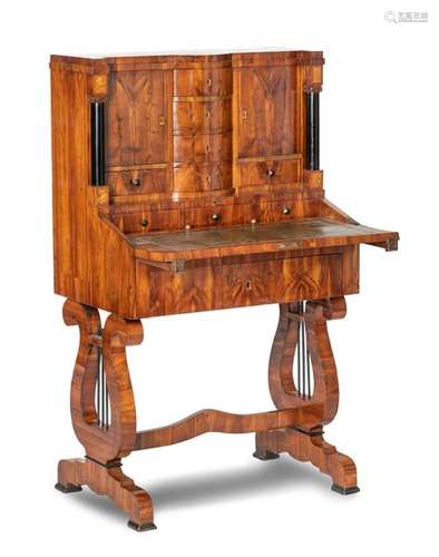 Petite Biedermeier lady's secretary. 19th century. 130x76x47 cm. Frame drawer, above it a foldable writing tablet in front of three drawers and one frame compartment. Top with six drawers and two doors, flanked by two ebonised full columns. Frame with lyre-shaped feet. Plum wood. Rest. Provenance: From a large South German private collection.