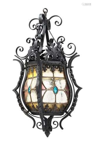 Lantern. France, 19th century. H. 70 cm. One side folds up. Iron, partly forged. Polychrome lead glazing. senile