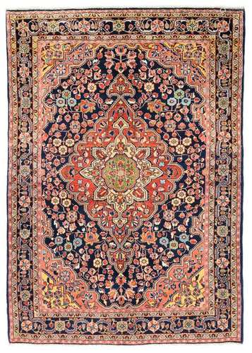 Djosan. Western Persia, circa 1940. 192 x 133 cm. Stylised floral vines cover the concentric inner field, which is dominated in the centre by an imposing red-ground medallion with palmette pendants. The dark blue-ground main border is decorated with a geometric and floral wavy vine border with a 