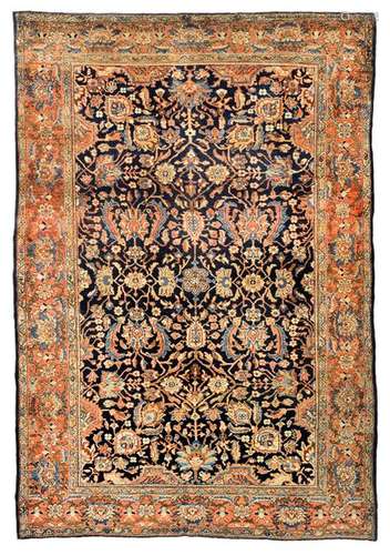 Sarouk-Ferahan. Western Persia, circa 1930. 193 x 131 cm. A repeat of blossoms and palmettes in golden yellow tones covers the dark blue background. The two-dimensional pattern is grid-like and densely drawn. The border design presents itself accordingly with a series of large and closely spaced floral motifs typical of the provenance. All in all, a compact weave with a shiny pile made of high-quality wool. Min. age-sp. insg. well preserved.