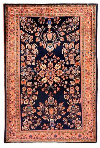 Blue-ground Saruk. Western Persia, circa 1940. 197 x 128 cm. Attractive saruk with a rare, dark blue-ground ground, which forms a splendid contrast to the stylised flower and palmette motifs in light pastel colours. The warm pattern colours, including rosé, salmon and apricot, also characterise the magnificent main border. Well preserved.