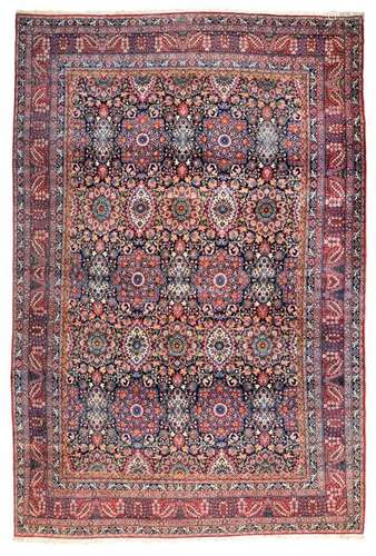 Imposing Kirman manufactured carpet. Southern Persia, circa 1930. 598 x 404 cm. The dark blue-ground field is covered with a dense repeat of flowers. Large rosette medallions alternate with two different elliptical flower motifs. The manufactory signet is located at the upper end of the knotting in a green-ground cartridge. A masterly work with vivid colours and with a great sense for detail. Provenance: Private property in Baden-Württemberg. - Min. age and usage esp. in good condition.