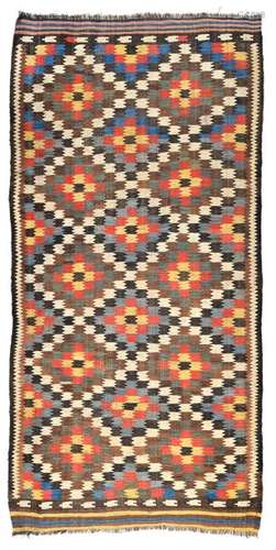 Veramin Kelim. Northern Persia, late 19th century. 277 x 138 cm. Housego names the interlocked knitting and the brown warp threads as a specific characteristic for the works from Garmsar, a village in the Veramin area. The jagged contours of the diamond repeat, which Housego calls the 