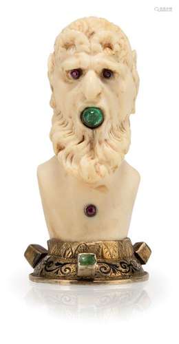 Head of a faun. Southern Germany, 18th and 19th centuries. H. 7.5 cm. Bust of the Faun made of ivory, fully round. In his mouth he holds an emerald cabochon, small rubies as eyes and on his chest. Vermeil mount with black enamel decoration and three more emeralds. Min. rep.