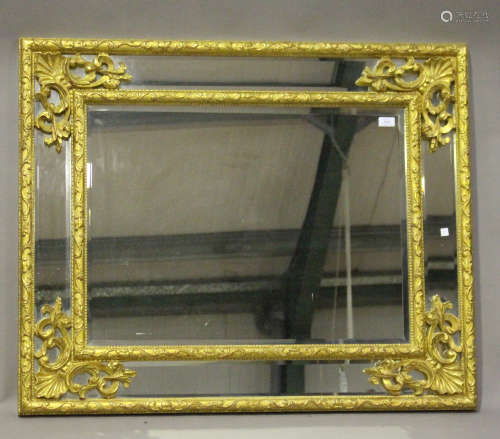 A 20th century rococo style giltwood framed rectangular wall mirror with scroll and stiff leaf