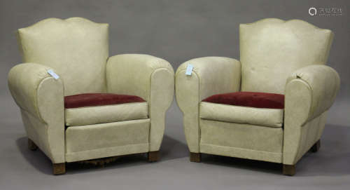 A pair of French Art Deco 'Moustache' club armchairs, upholstered in cream leatherette, on block