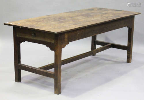 A 19th century oak farmhouse kitchen table, fitted with a single end drawer, raised on block legs