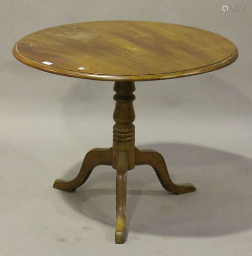 An early 20th century walnut circular tip-top wine table, raised on a turned column and tripod