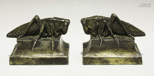 A pair of Art Deco plated copper-cased bookends, each modelled as a locust on a shaped pedestal,