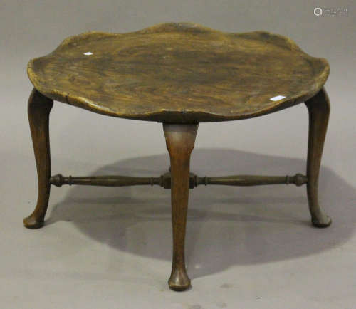 An early 20th century provincial style elm and stained beech occasional table, the slightly dished