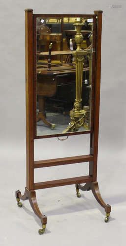 A Regency mahogany cheval mirror with rising ratchet mechanism, on sabre legs and brass castors,