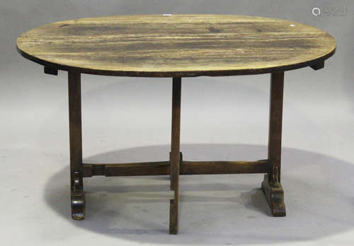 A late 18th/early 19th century French provincial walnut oval tip-top trestle table, on block