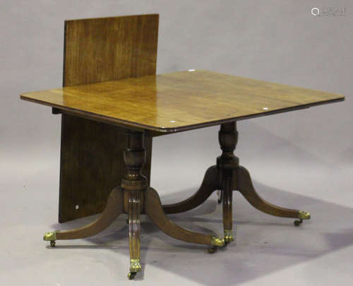 A George III mahogany rectangular dining table with single extra leaf, raised on turned columns