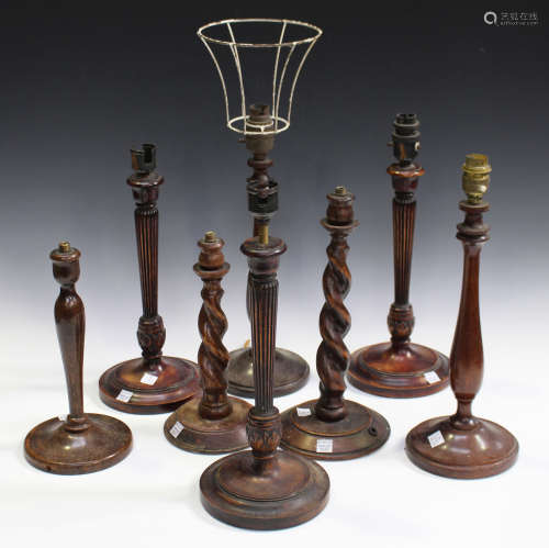 A set of three early 20th century walnut table lamps with carved leaf knops, height 30cm, together