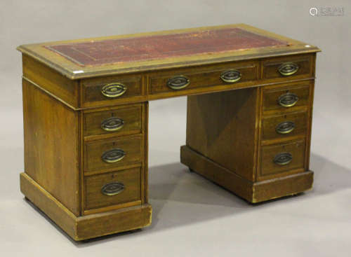 A late Victorian oak twin pedestal desk, the moulded top inset with a gilt-tooled red leather