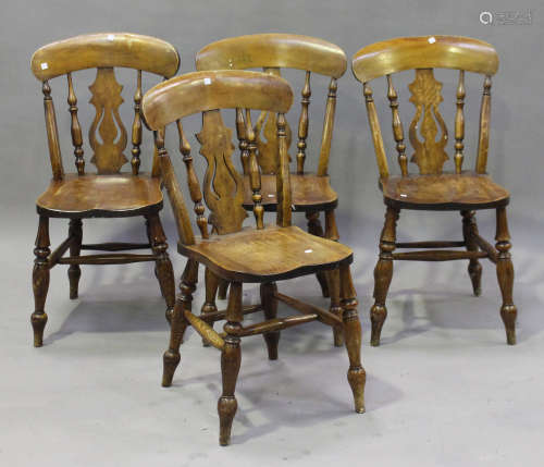 A set of four early 20th century beech and elm Windsor dining chairs, the solid seats raised on