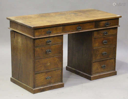 An Edwardian oak twin pedestal desk, fitted with eleven drawers, on plinth bases, height 74cm, width