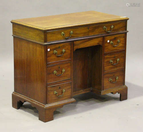 An early 19th century mahogany kneehole desk, the hinged lid revealing a writing surface, above an