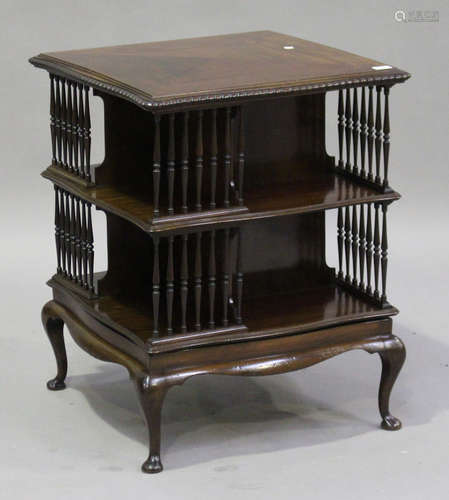 An Edwardian mahogany revolving library bookcase, the gadrooned serpentine top above turned