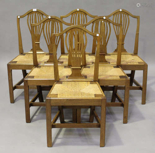 A set of six George III provincial walnut pierced splat back dining chairs, inset with rush seats,