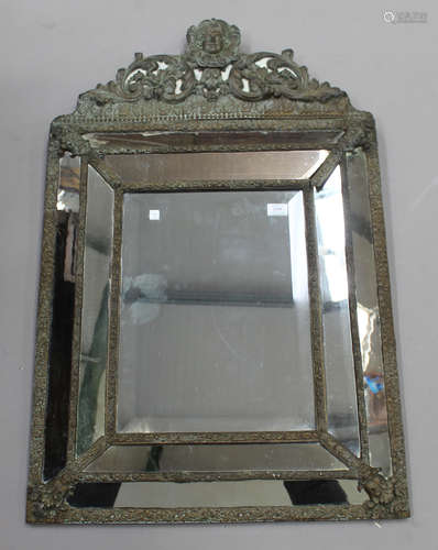 A 20th Dutch style brass mounted sectional wall mirror, the arched crest and frame with applied