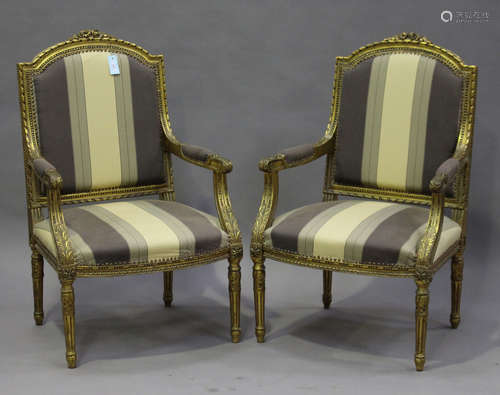 A pair of early/mid-20th century Louis XVI style giltwood fauteuil armchairs, the overstuffed