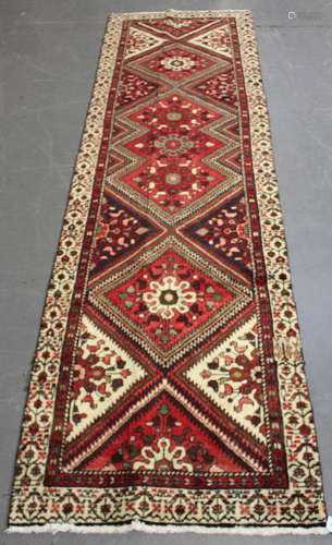 A Hamadan runner, North-west Persia, mid-20th century, the red field with a single column of stepped