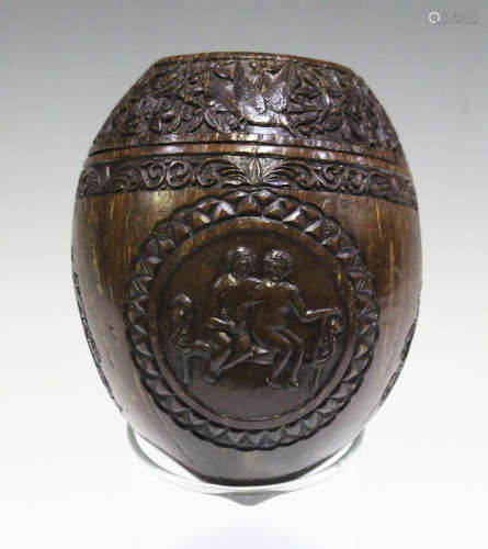 A 19th century carved coconut, finely worked with a band of birds and foliage above three reserves