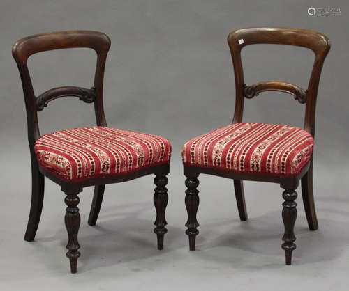 A set of eight mid-Victorian mahogany spoon back dining chairs, the overstuffed seats raised on