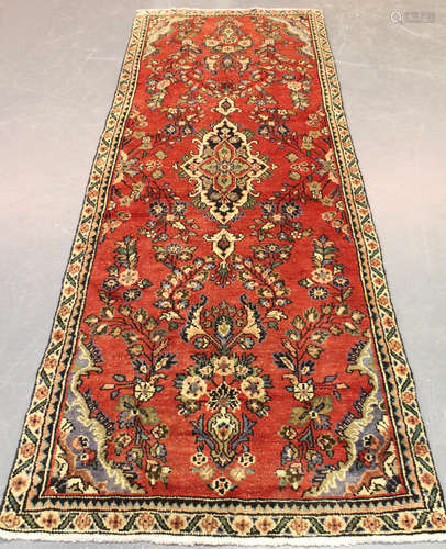 A Hamadan runner, North-west Persia, mid-20th century, the red field with a lozenge medallion,