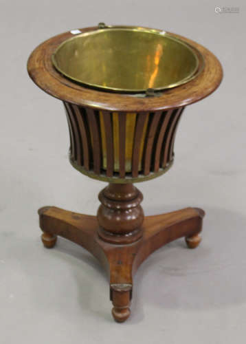 A mid-19th century mahogany jardinière stand, the slatted body fitted with a brass liner, raised