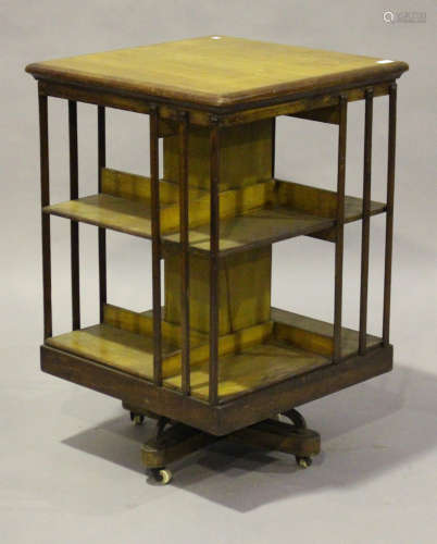 An Edwardian oak and mahogany revolving bookcase by Maple & Co, the slatted sides raised on a cast