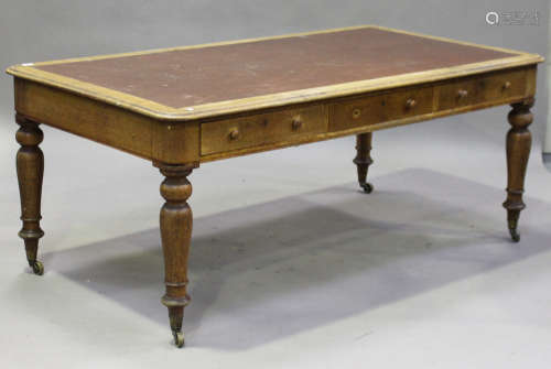 A Victorian oak library table, the moulded top inset with a brown leatherette writing surface,