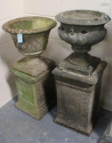 Two 20th century cast composition stone garden urns, both raised on square pedestals, heights