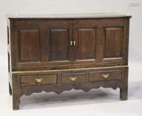 An 18th century oak mule chest, fitted with a pair of panelled doors above three drawers, on