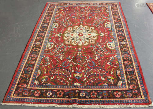 A Hamadan rug, North-west Persia, mid-20th century, the red field with a shaped ivory medallion,