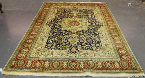 A Tabriz carpet, Central Persia, late 20th century, the ink blue field with an ivory medallion,