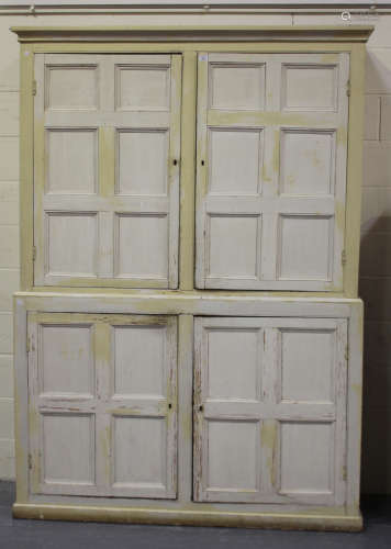 A 19th century white painted pine kitchen cabinet, fitted with four panelled doors enclosing