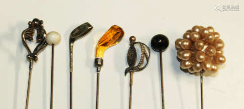 A group of various hat and stick pins, including two silver topped examples, one in the form of a