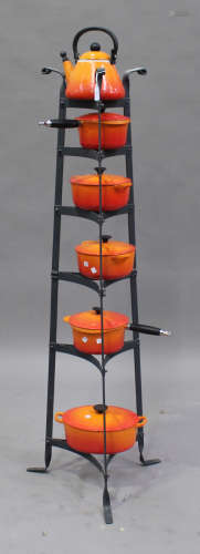 A group of Le Creuset orange enamelled kitchenware, comprising kettle, two saucepans and three