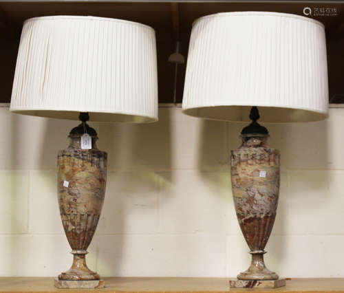 A pair of late 19th/early 20th century rouge marble table lamps, each carved in the form of a